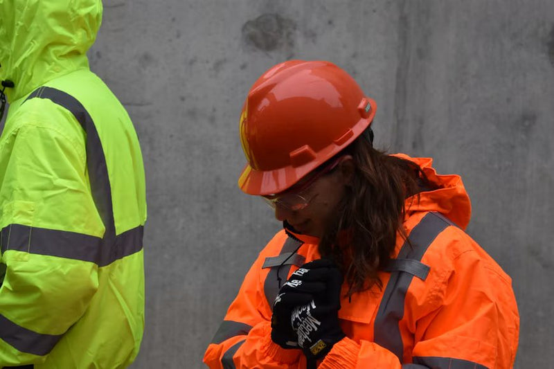 Construction workers in hard hats and high-visibility jackets on site