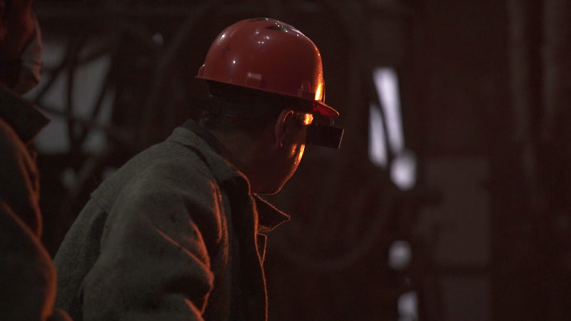 Worker in a red hard hat on a dim job site
