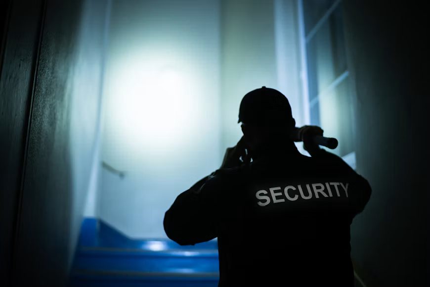 Security guard holding a flashlight on night patrol